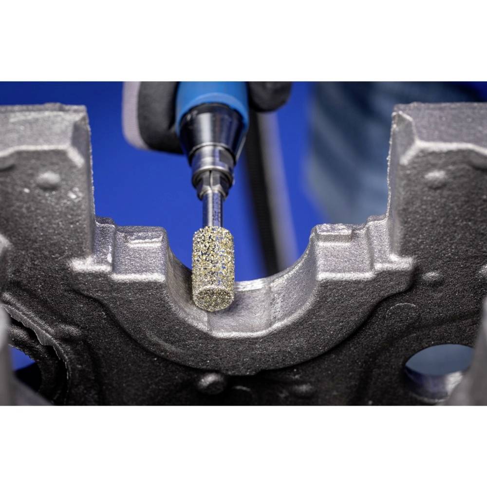Ein Schleifwerkzeug bearbeitet präzise die Oberfläche eines metallischen Werkstücks in einer Werkstattumgebung.
