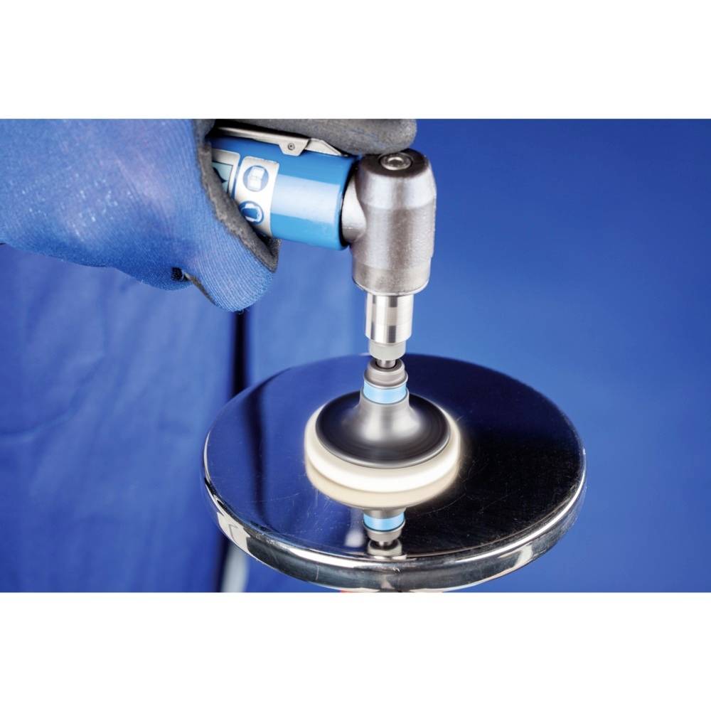 Ein Arbeiter poliert eine Metalloberfläche mit einer elektrischen Poliermaschine. Die Oberfläche reflektiert das Licht.