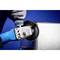 'Eine Person in Handschuhen schleift eine Metallkante mit einem Elektrowerkzeug. Blaue Oberfläche im Hintergrund.'