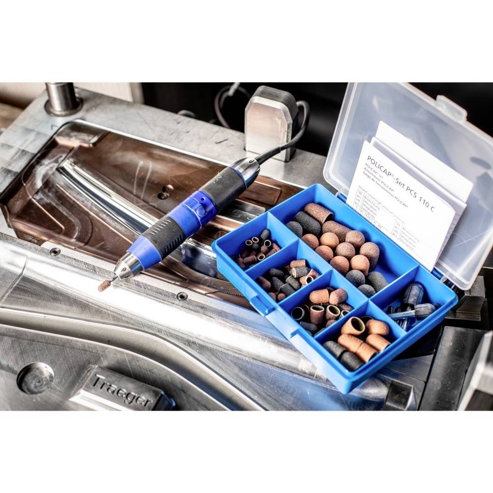 Multifunktionales Werkzeug mit Schleif- und Poliereinsätzen in geöffneter Box auf metallischer Werkbank.