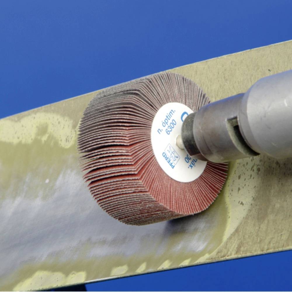 Schleifwerkzeug bearbeitet eine Metalloberfläche. Die rotierende Schleifscheibe entfernt Material und hinterlässt eine glatte Fläche.