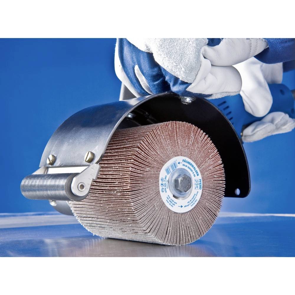 Arbeiter in Schutzhandschuhen bedient eine Schleifscheibe, die eine Metallfläche bearbeitet. Fokus liegt auf der Schleifscheibe in Aktion.