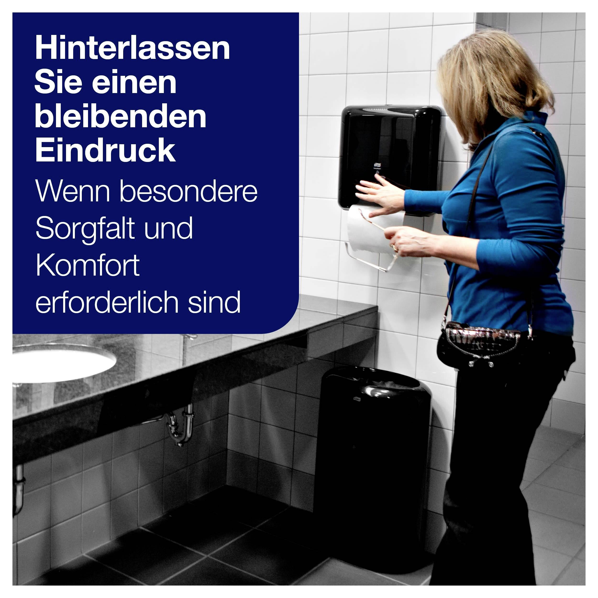 'Eine Person in einem Badezimmer nutzt einen Papierspender. Text: Hinterlassen Sie einen bleibenden Eindruck. Wenn besondere Sorgfalt und Komfort erforderlich sind.'