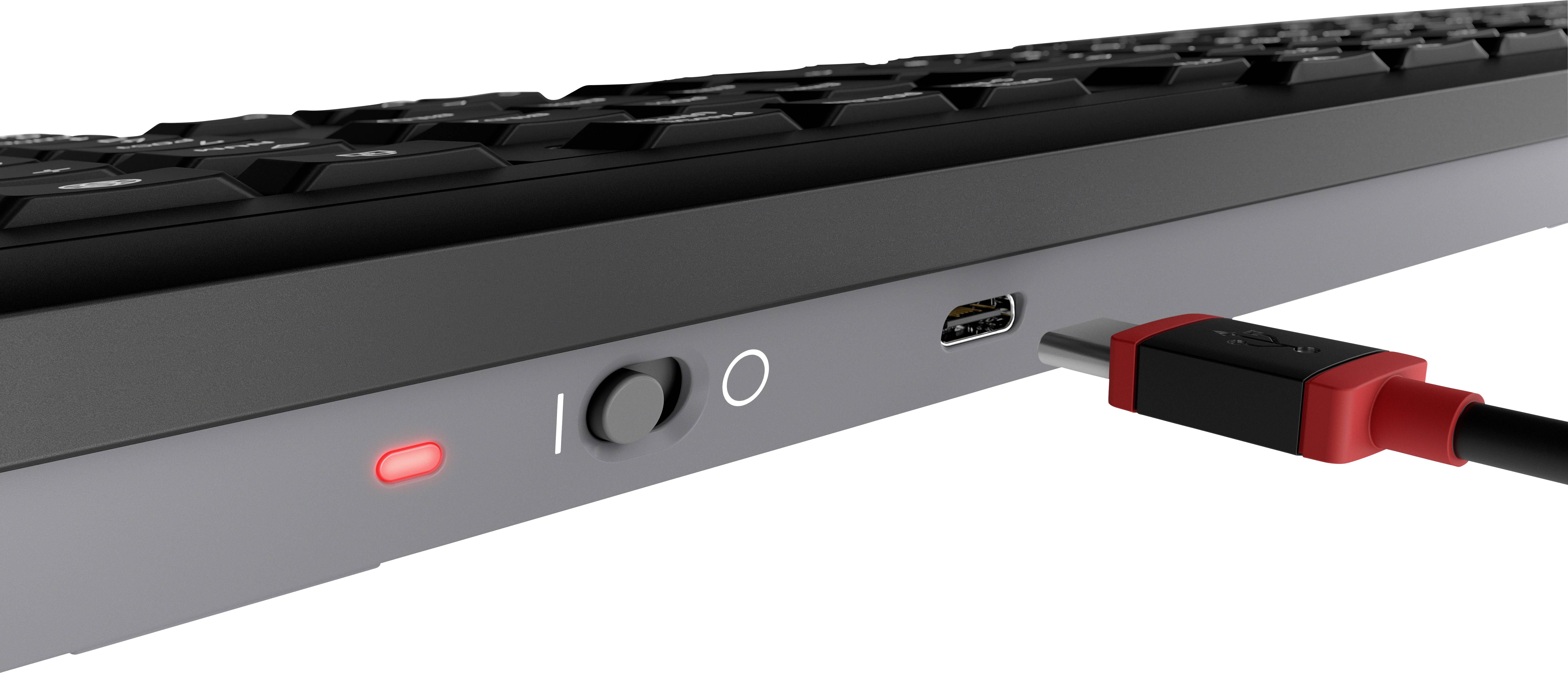 Seitliche Ansicht einer Tastatur mit USB-C-Anschluss und rotem Kabel; eine LED-Anzeige leuchtet rot.
