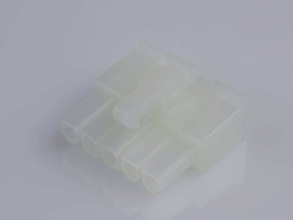 Ein weißer Polyamid-Stecker mit sechs Steckplätzen, liegend auf einer glänzenden Oberfläche.