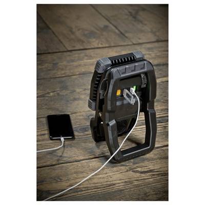Tragbarer elektrischer Heizlüfter mit einem Mobiltelefon-Ladegerät daneben auf einem Holzboden, verbunden durch ein weißes Kabel.