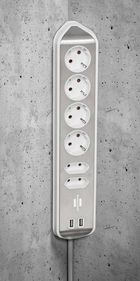 Steckdosenleiste mit fünf Steckplätzen und zwei USB-Anschlüssen an einer Betonwand montiert. Geeignet für Schreibtischarbeit.