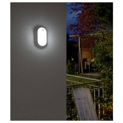 Gespaltenes Bild, das eine leuchtende ovale Wandleuchte im Innenraum neben einer nächtlichen Außenansicht eines Hauses, von Bäumen und einem Geländer zeigt.