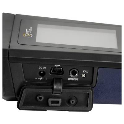 Nahaufnahme einer schwarzen Gerätesteuerplatine mit leerem Display, DC-9V-Stromeingang, USB-Anschluss, Ausgangsanschluss und kleiner CAL-Taste, wobei die Schutzabdeckung offen ist.