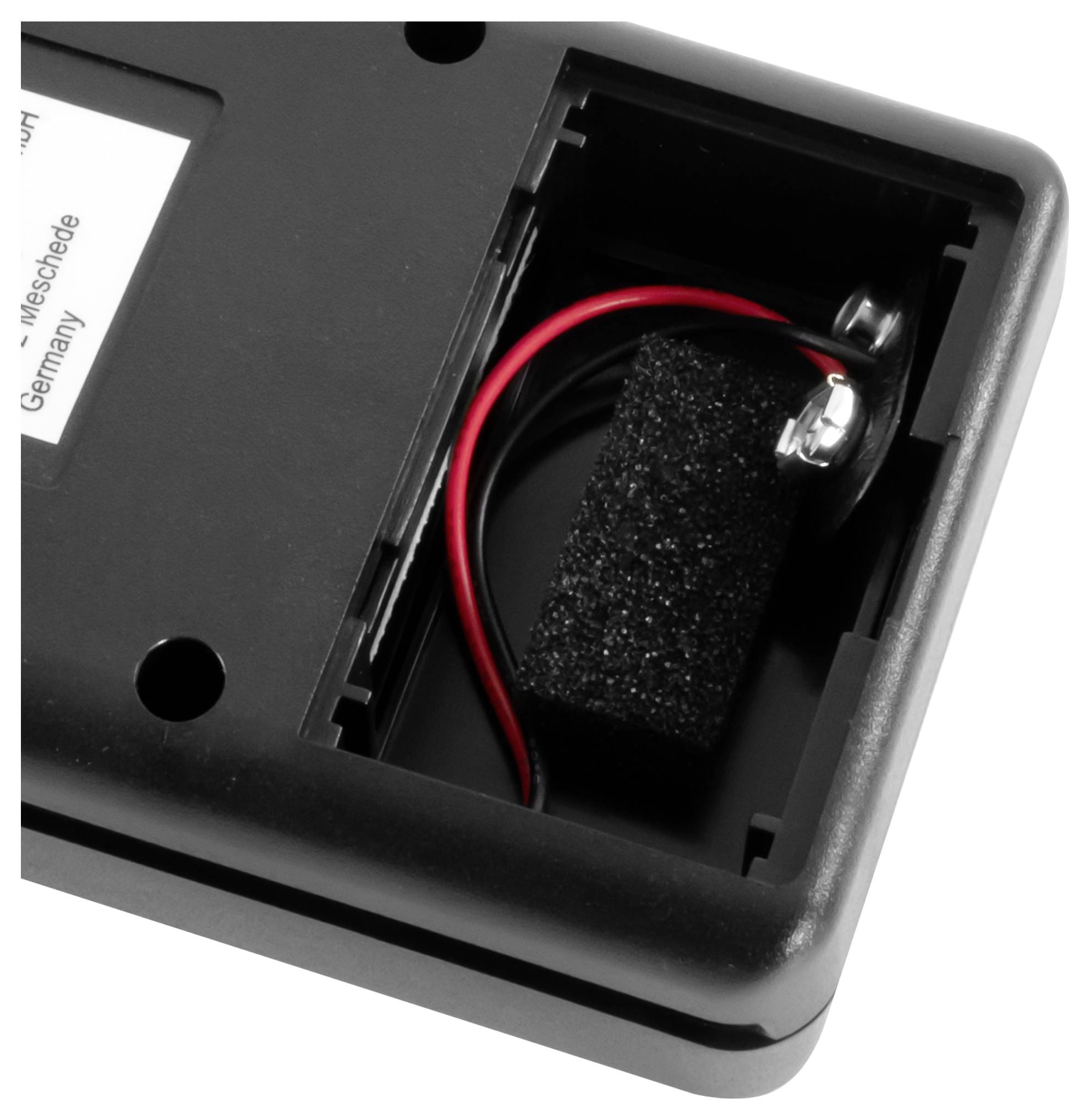 Öffnen Sie das Batteriefach eines schwarzen Geräts mit einer 9-V-Batterieklemme mit roten und schwarzen Drähten und Schaumstoffpolsterung