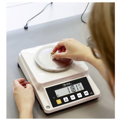 Person wiegt einen kleinen Ring auf einer digitalen Waage in einer Labor- oder Werkbankumgebung, wobei das Display 11,81 anzeigt.