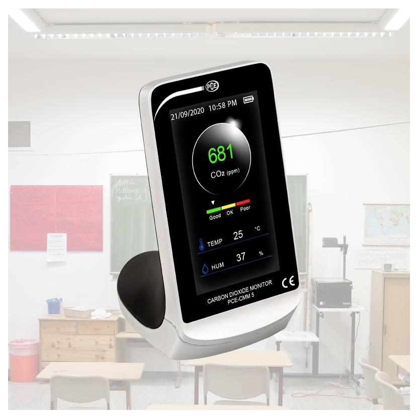 Digitales Kohlendioxidmessgerät, das 681 ppm anzeigt, mit einer Temperatur von 25°C und einer Luftfeuchtigkeit von 37%, gezeigt in einem Klassenzimmer.