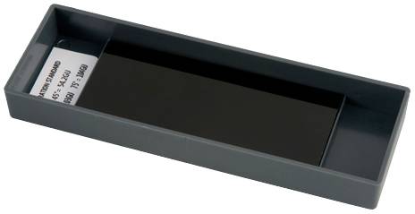 Rechteckige Kunststoffschale mit einem schwarzen Objekt aus Glas oder Kunststoff und einer Papierbeschriftung im Inneren.