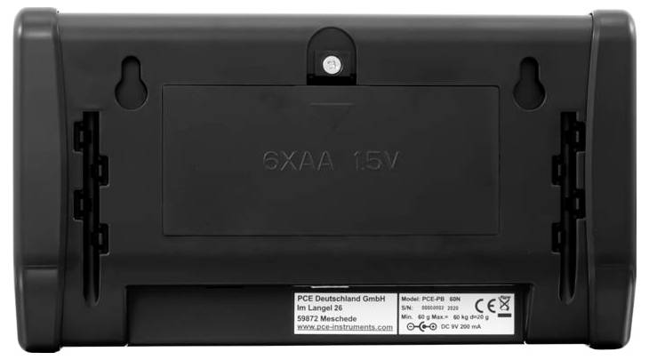 Rückseite eines schwarzen elektronischen Geräts mit einem aufklappbaren Batteriefach mit der Aufschrift „6XAA 1,5V" und einem Herstelleretikett am unteren Ende.