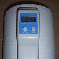 Feuchtemessgerät zeigt 9,4 Prozent auf digitalem Display. Gerät liegt auf einer weißen Oberfläche.