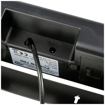 Ein Kabelanschluss an einem elektronischen Gerät, sichtbar mit einem Etikett mit technischen Spezifikationen und Symbolen.