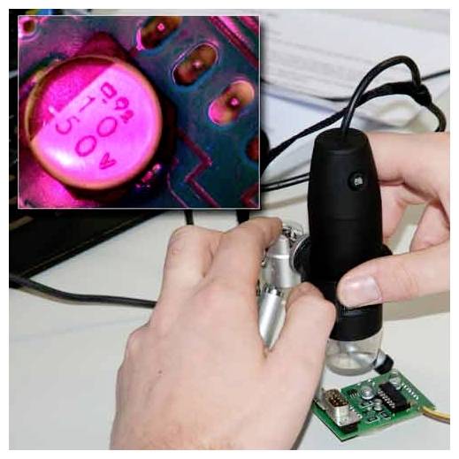 Hände, die ein Mikroskop verwenden, um eine kleine elektronische Leiterplatte zu inspizieren, mit einer eingefügten Nahaufnahme eines rosa Kondensators mit der Aufschrift „50V 220F".