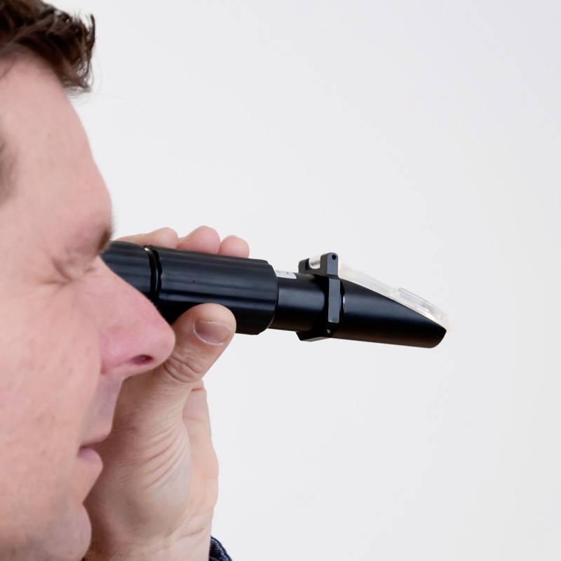 Ein Mann hält ein Otoskop und schaut durch das Objektiv, als ob er eine Untersuchung durchführt.