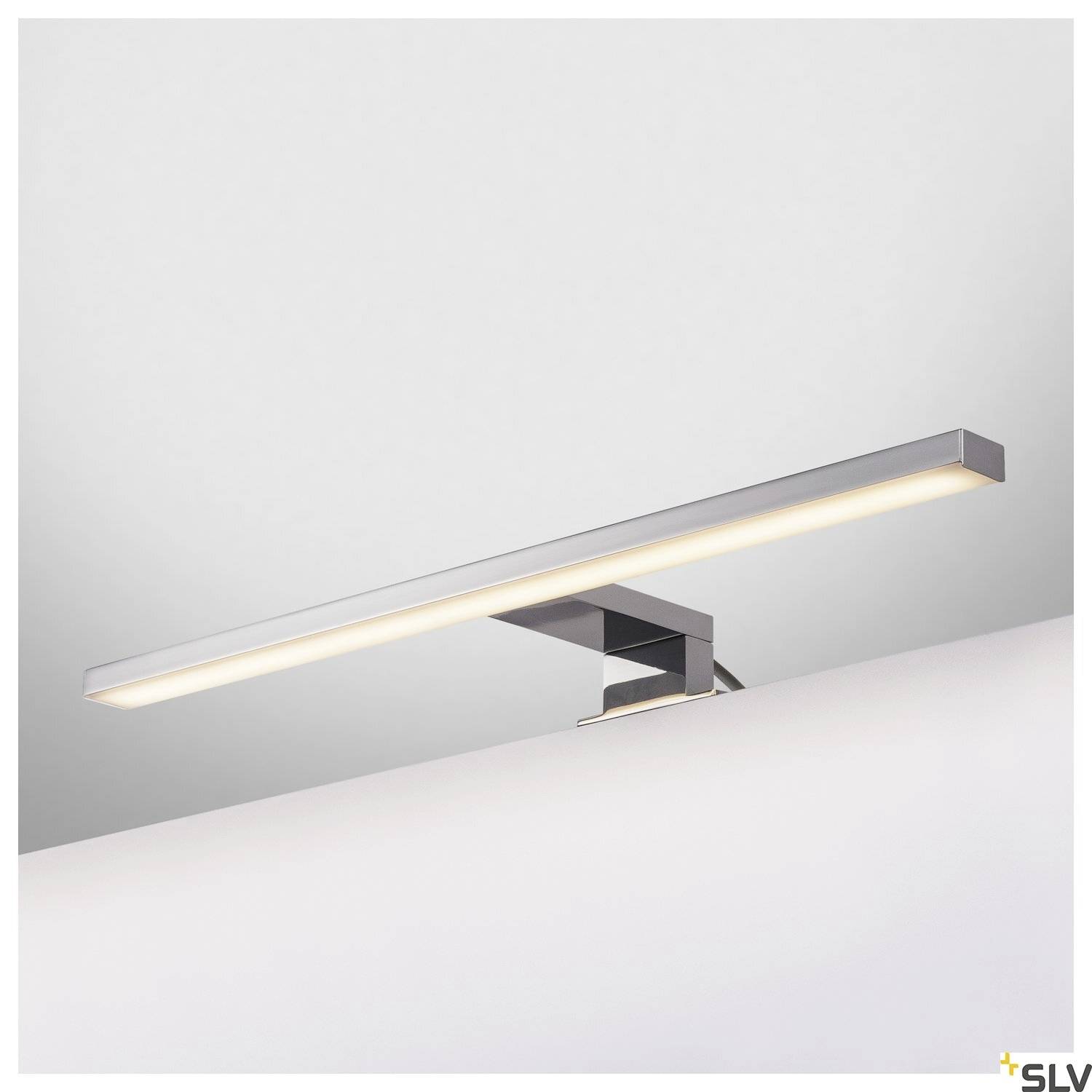 Moderne, rechteckige LED-Wandleuchte in Chromoptik, montiert über einem Spiegel, erzeugt gleichmäßiges, warmweißes Licht.