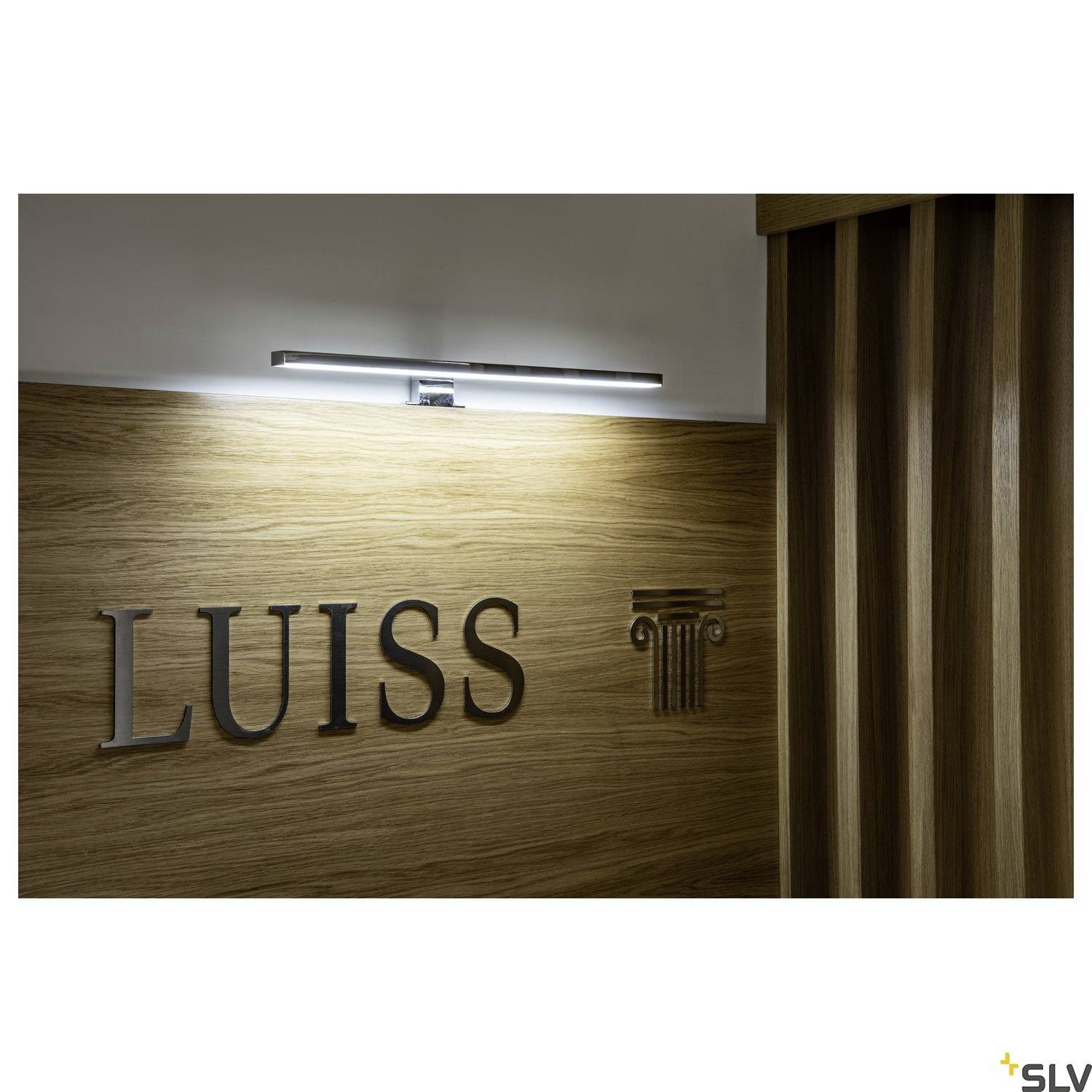 'LUISS' steht in schwarzen Großbuchstaben an einer Holzplatte, daneben ein klassisches Säulensymbol. Oben ist eine Lampe montiert.