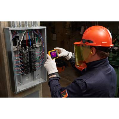 Ein Techniker in Schutzkleidung benutzt eine Wärmebildkamera zur Inspektion eines offenen Sicherungskastens, um elektrische Probleme zu erkennen.