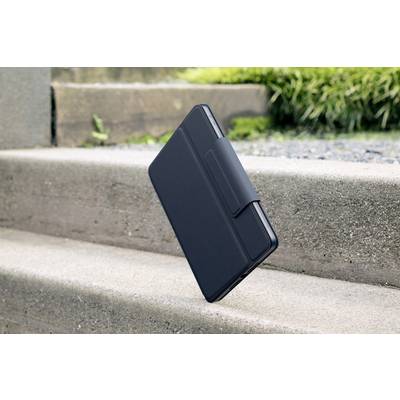 Tablet mit schwarzer Hülle schwebt über einer Betontreppe im Freien. Im Hintergrund ist Gras zu sehen.
