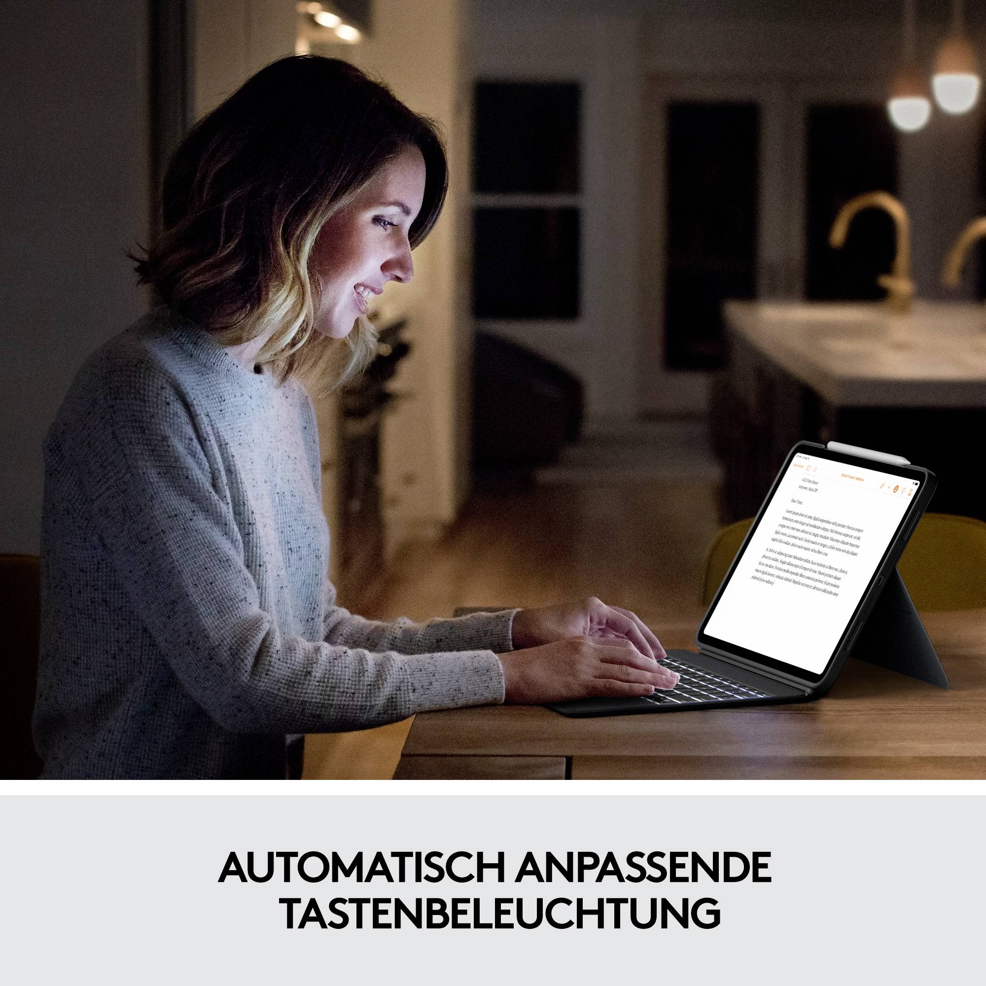 Eine Frau arbeitet abends an einem Tablet mit automatisch angepasster Tastenbeleuchtung, was das Tippen in dunkler Umgebung erleichtert.