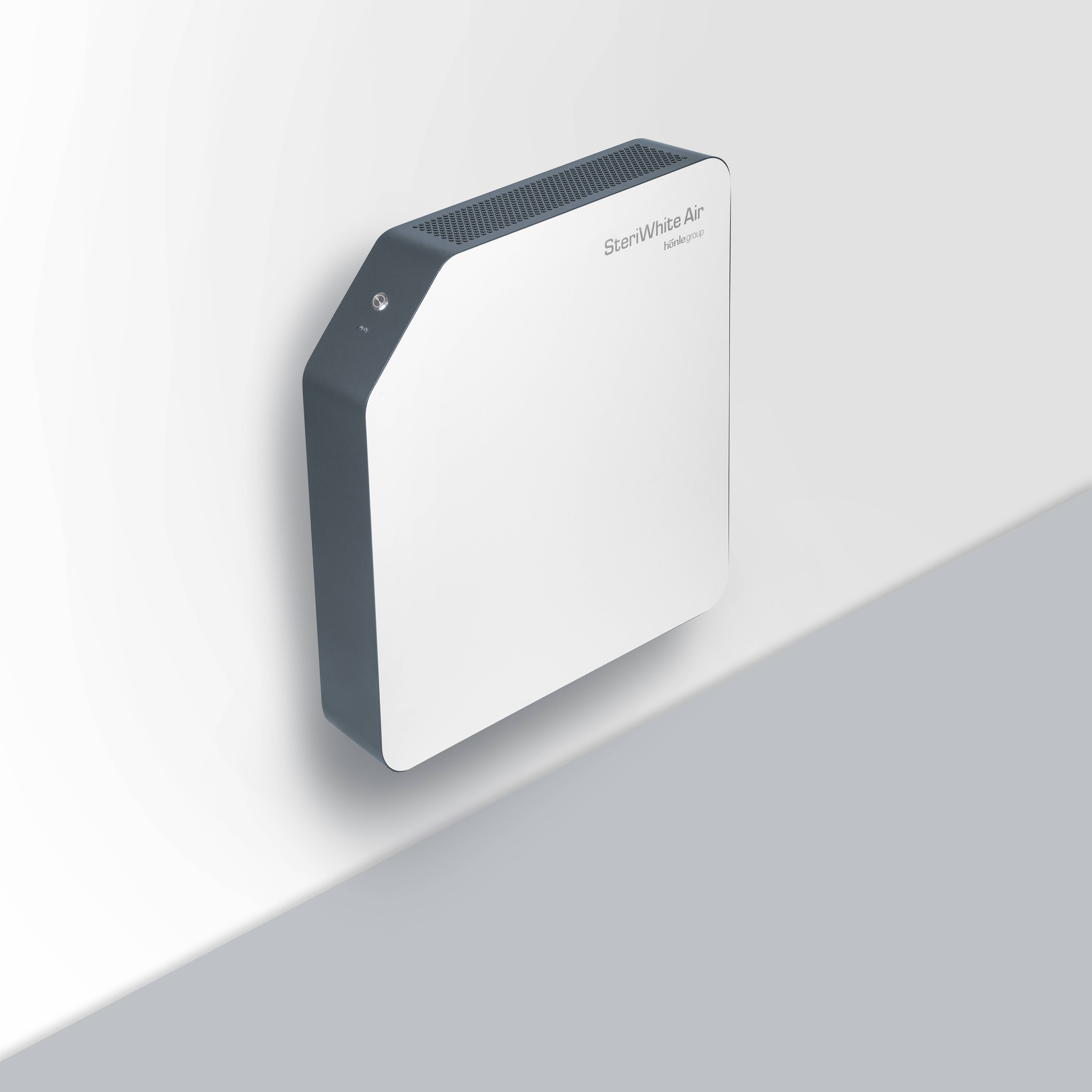 Luftreiniger an der Wand montiert mit dem Namen 'StormWhite Air'. Kompakte, schlanke Bauweise, passend für moderne Innenräume.