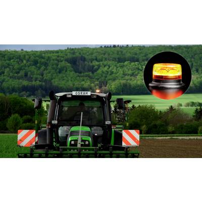 Ein Traktor auf einem Feld vor einem Waldhintergrund. Im oberen Teil ist ein oranges Warnlicht vergrößert dargestellt.