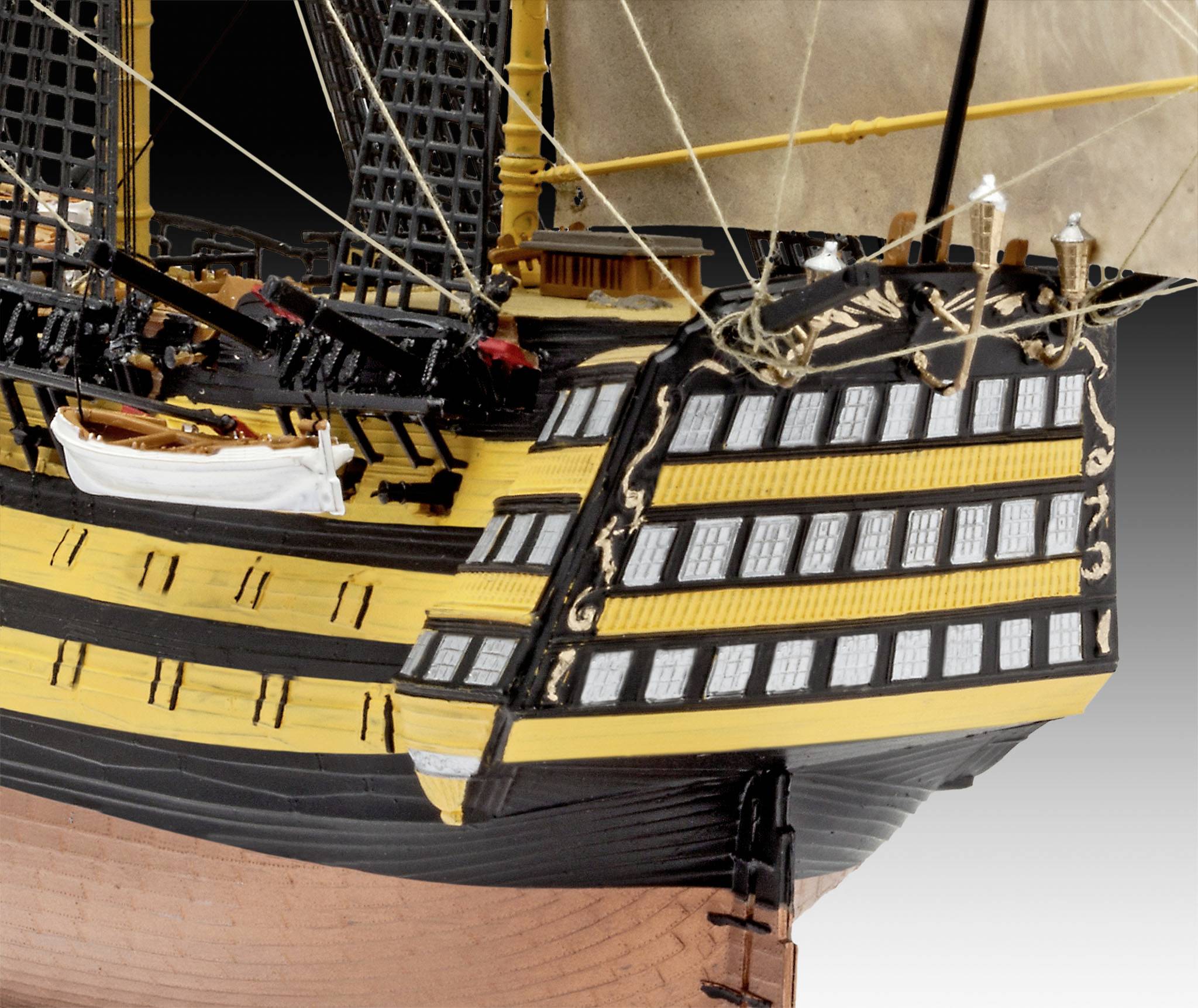 Teil eines historischen Schiffmodells mit markanter gelb-schwarzer Lackierung und zahlreichen Fenstern am Heck.