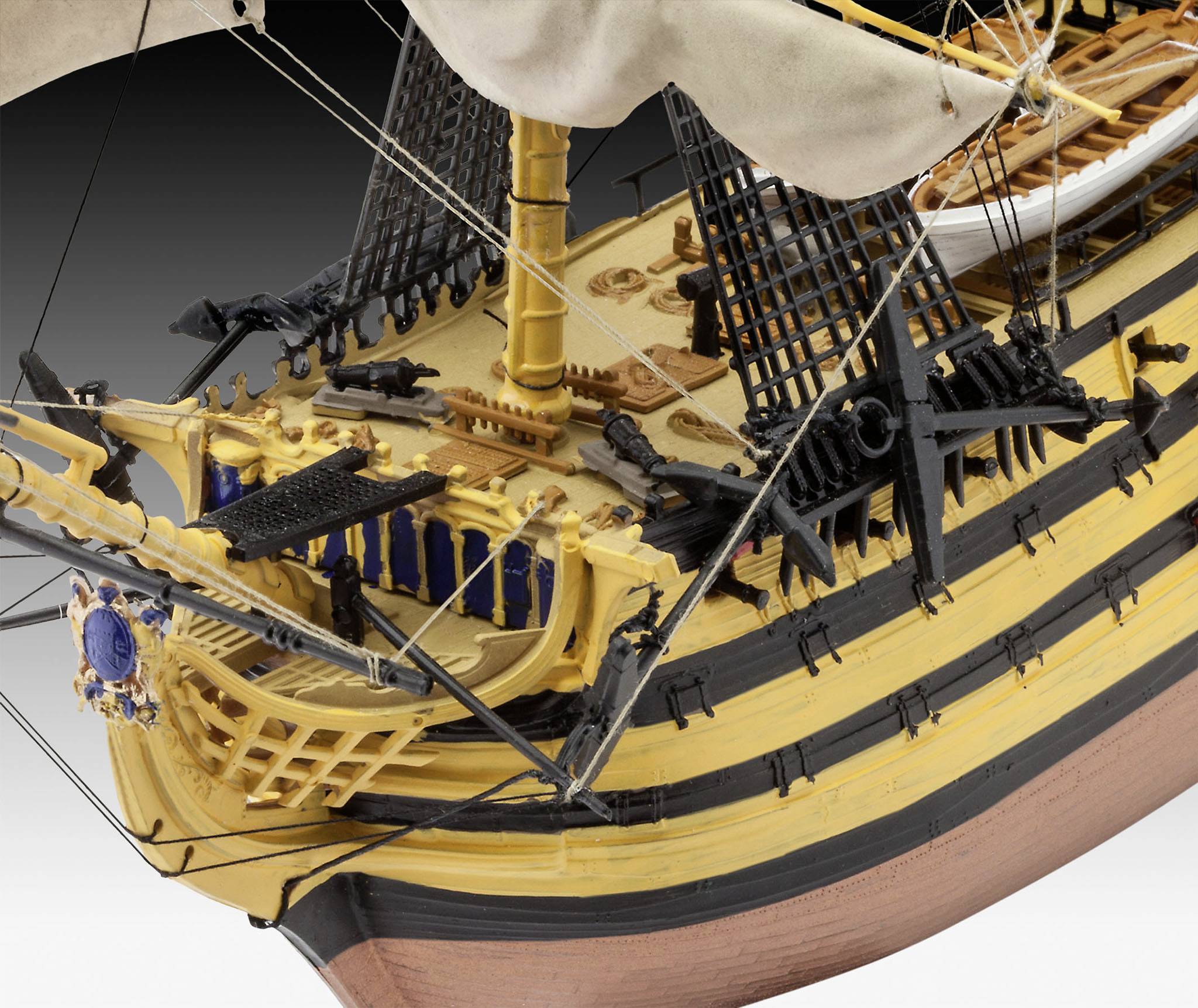 Ein detailliertes Modell eines historischen Segelschiffs. Der Bug zeigt ein reich verziertes Geländer und zahlreiche Takelagen.