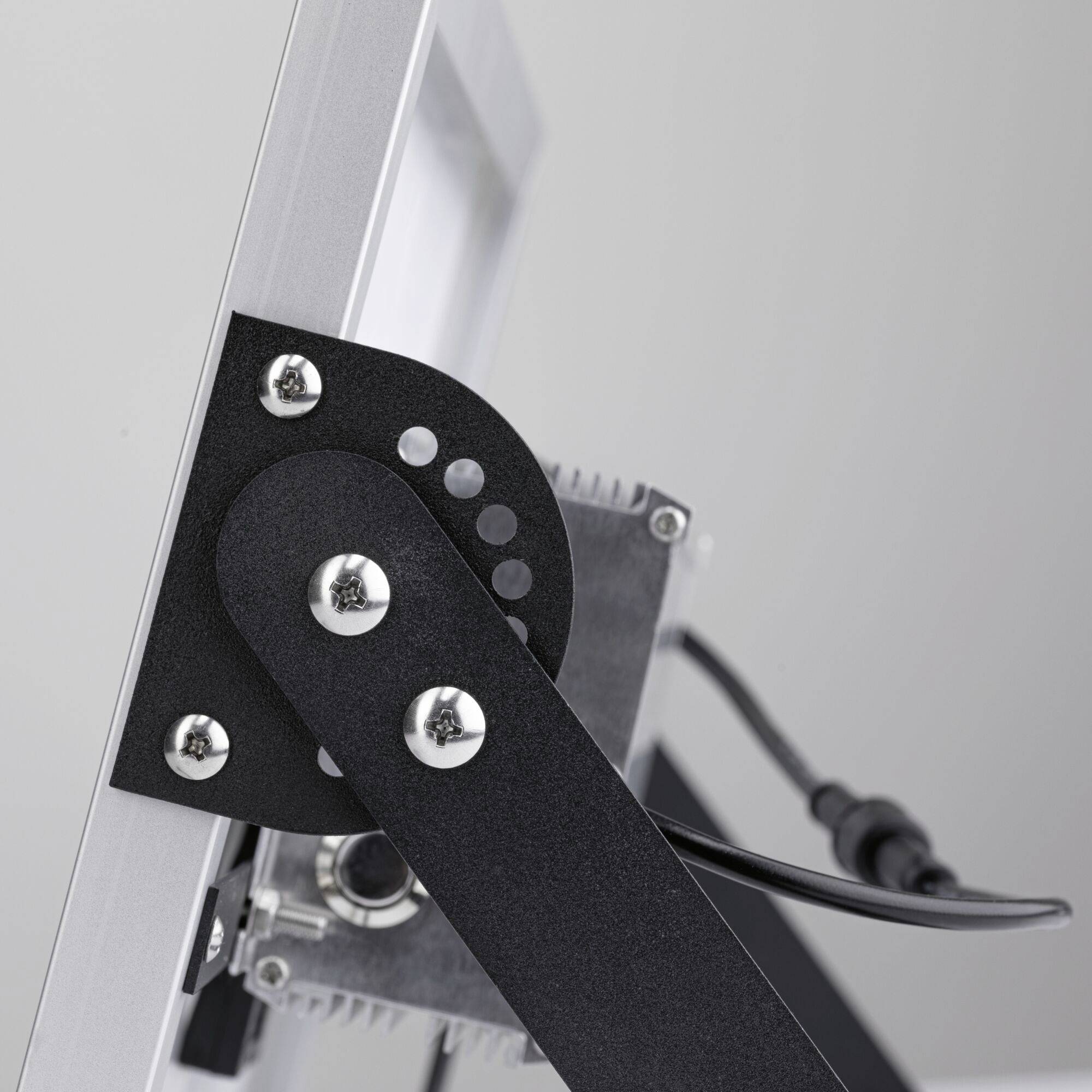 Metallmechanismus eines schwenkbaren Halters, der an einem Bildschirm oder Gerät montiert ist, zeigt Schrauben und Kabel.