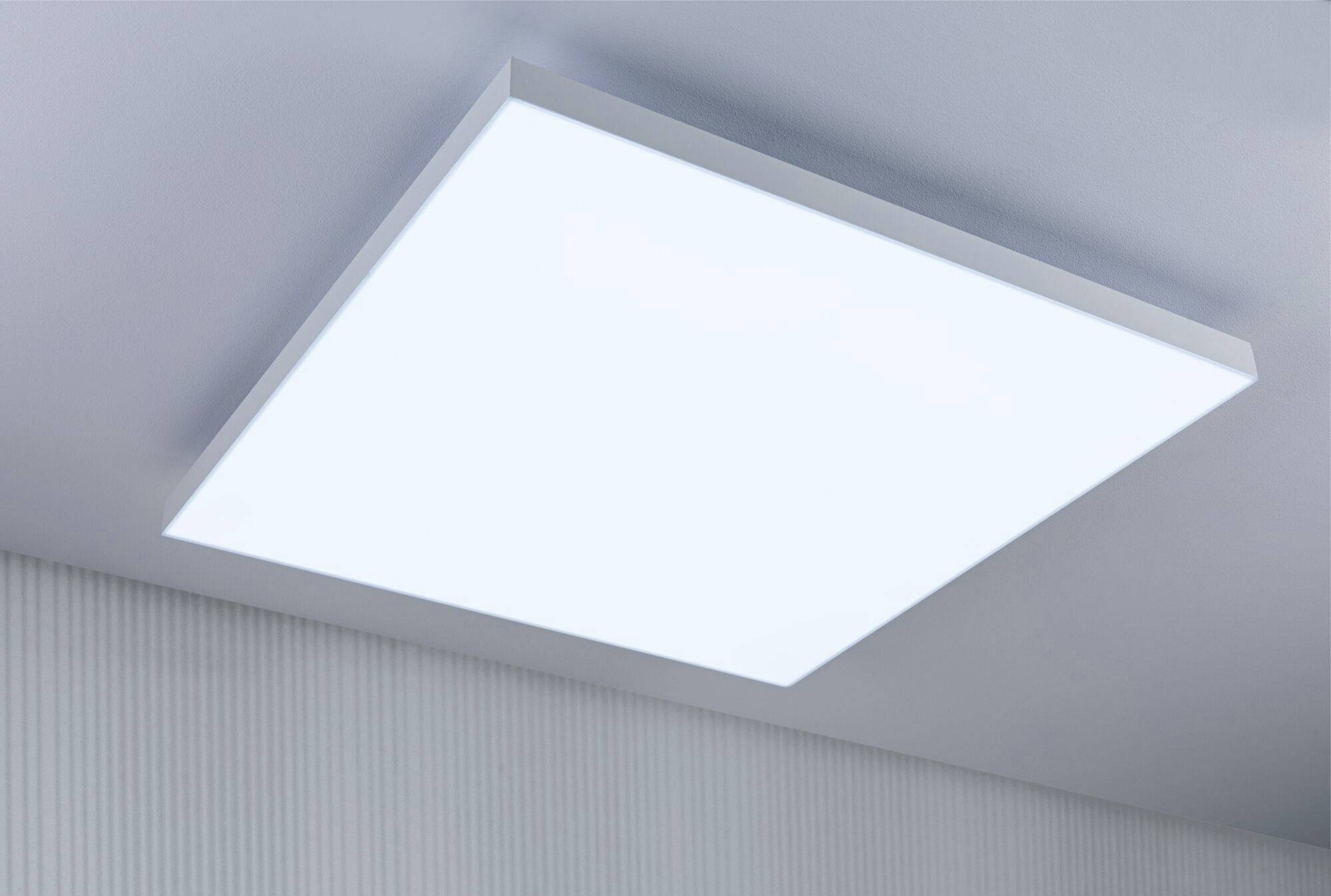 Beleuchtetes LED-Deckenpaneel in einem modernen Raum, gleichmäßig leuchtend, montiert an einer hellgrauen Decke.