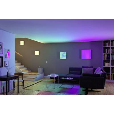Ein modern eingerichtetes Wohnzimmer mit einem Sofa, einem Tisch und stimmungsvoller, bunter Beleuchtung an der Wand.