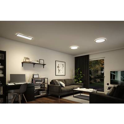 Ein modernes Wohnzimmer mit einem Schreibtischbereich links, zwei Sofas und einem Couchtisch rechts. Große Fenster bieten Blick ins Freie.