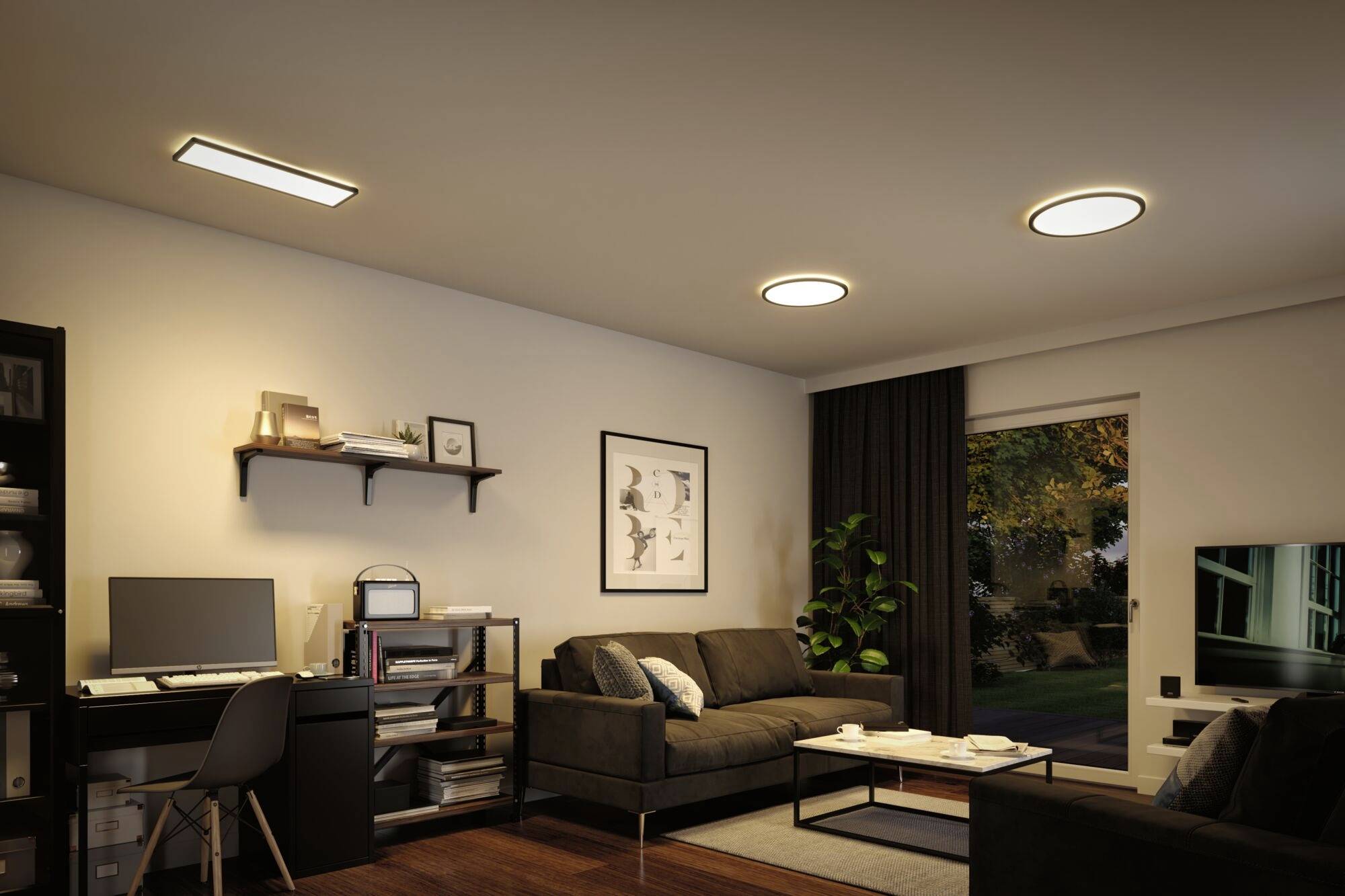 Ein gemütliches Wohnzimmer mit einem Schreibtisch und zwei Sofas. Regale, Pflanzen und ein Fenster sorgen für Atmosphäre und Tageslicht.