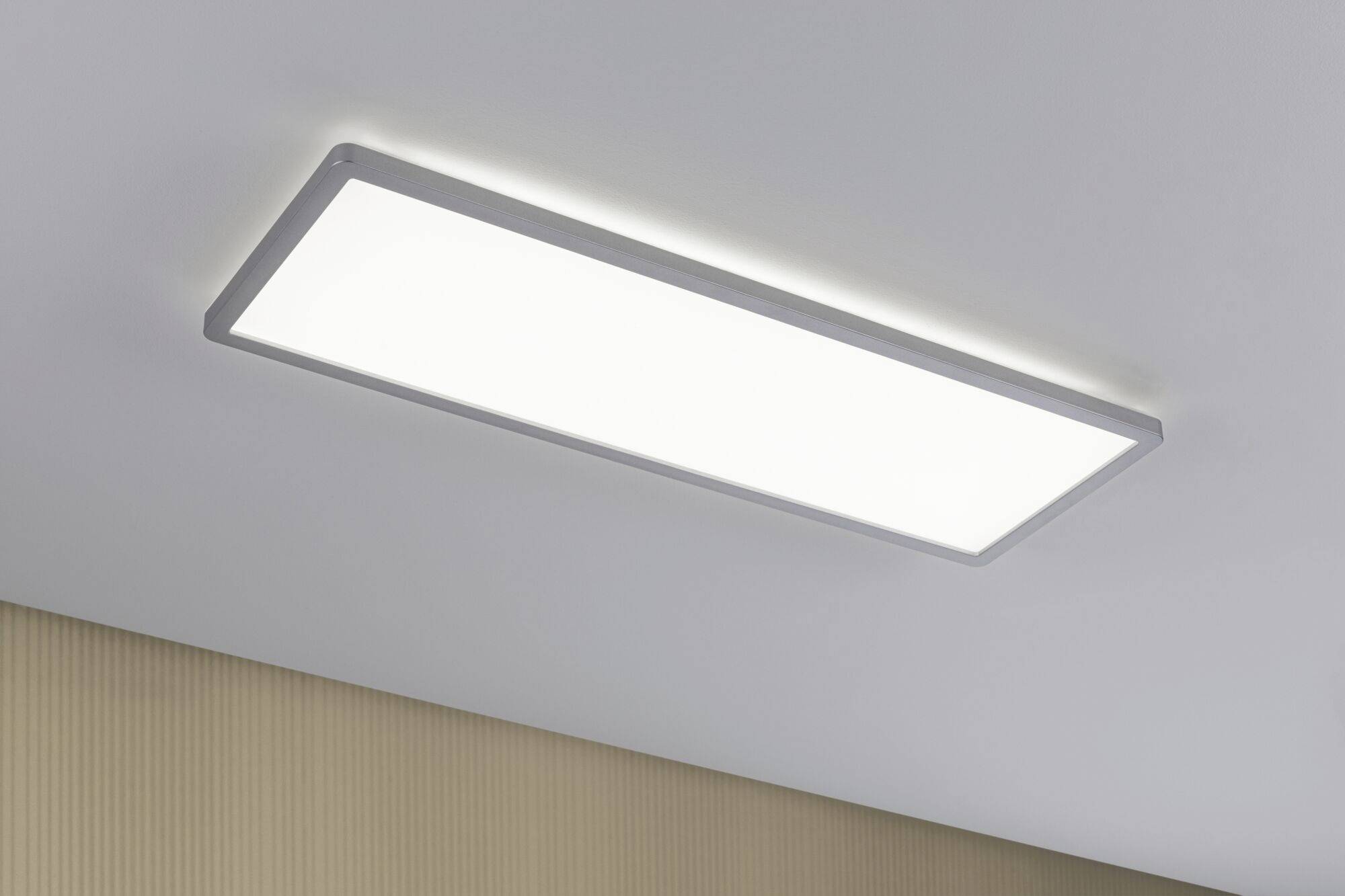 Rechteckige LED-Deckenleuchte an einer weißen Decke. Sie leuchtet hell und gleichmäßig, bietet moderne und energiesparende Beleuchtung.