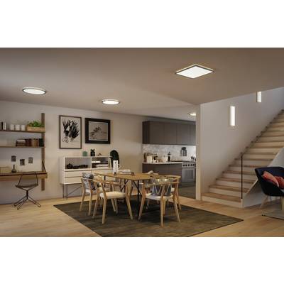Modernes Esszimmer mit Holztisch, sechs Stühlen und dekorativen Regalen. Im Hintergrund eine Küche mit grauen Schränken.