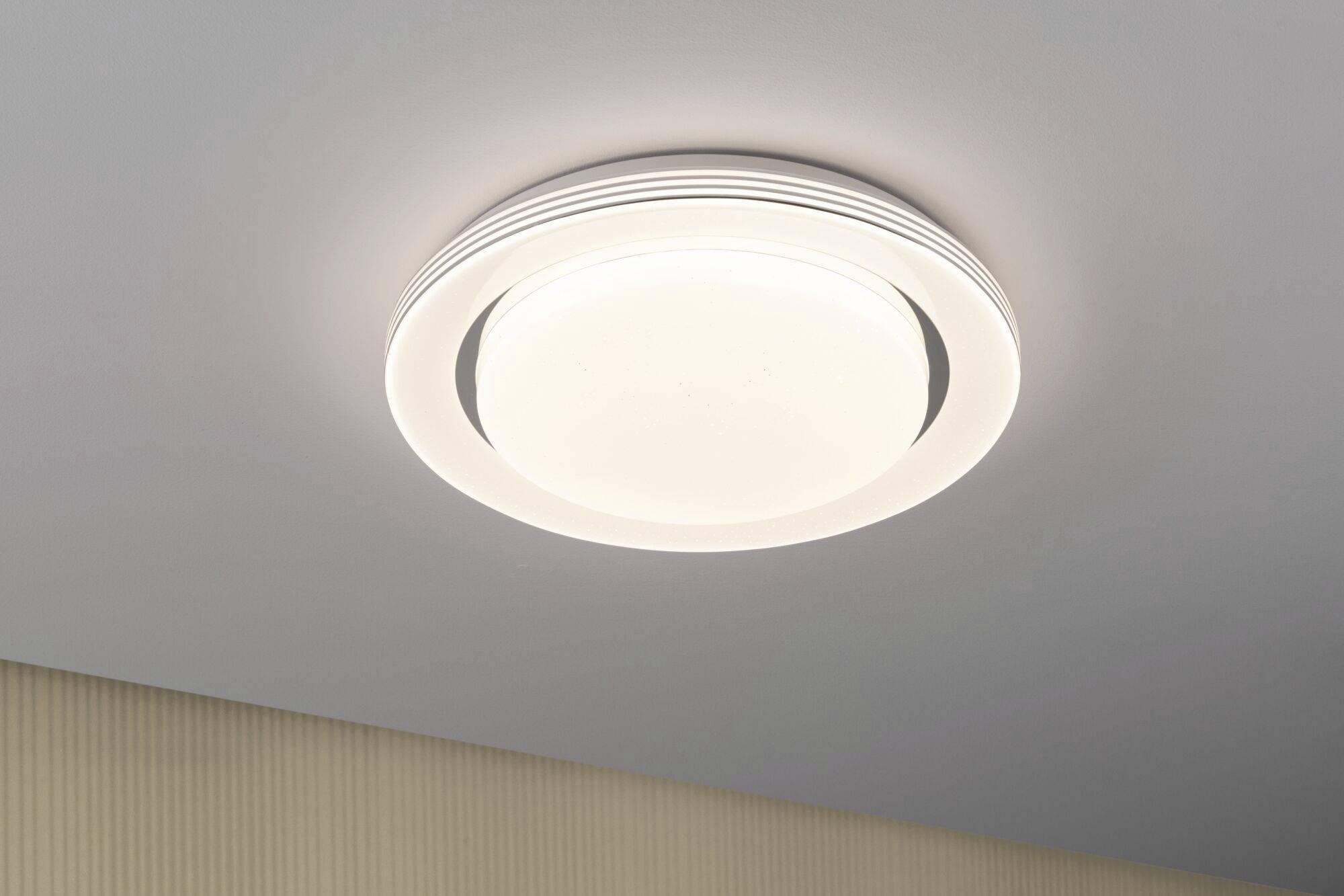 Moderne Deckenleuchte mit rundem, minimalistischem Design beleuchtet einen Raum gleichmäßig.
