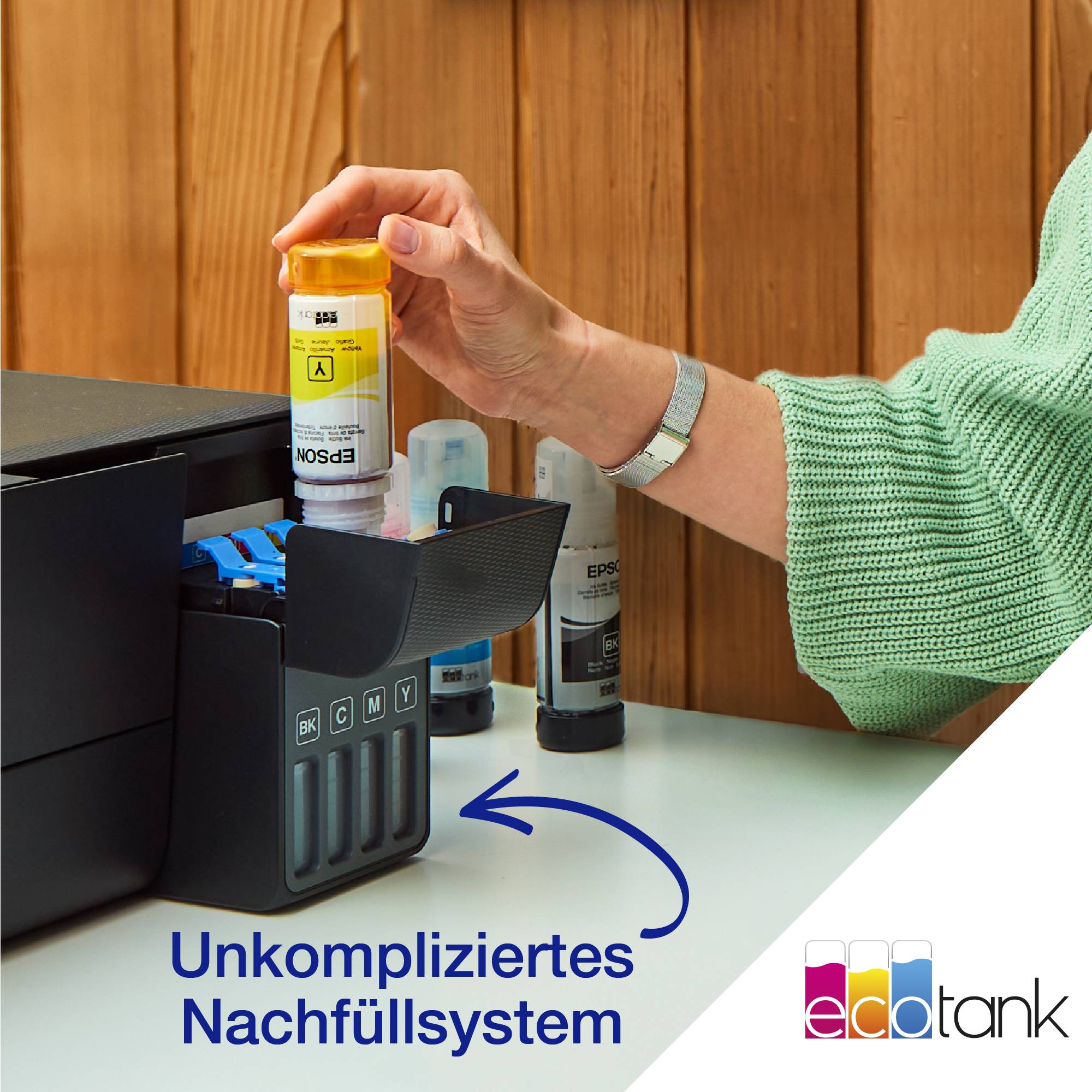 Eine Hand füllt eine gelbe Tintenkartusche an einem Drucker nach. Text unten: 'Unkompliziertes Nachfüllsystem'.