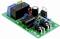 Eine grüne elektronische Schaltung mit verschiedenen Komponenten, darunter ein schwarzes Relais, ein IC-Chip, Potentiometer und ein Kondensator.