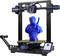 Ein 3D-Drucker druckt eine blaue Figur in Form eines futuristischen Soldaten. Der Drucker zeigt Fortschritt auf einem Bildschirm.