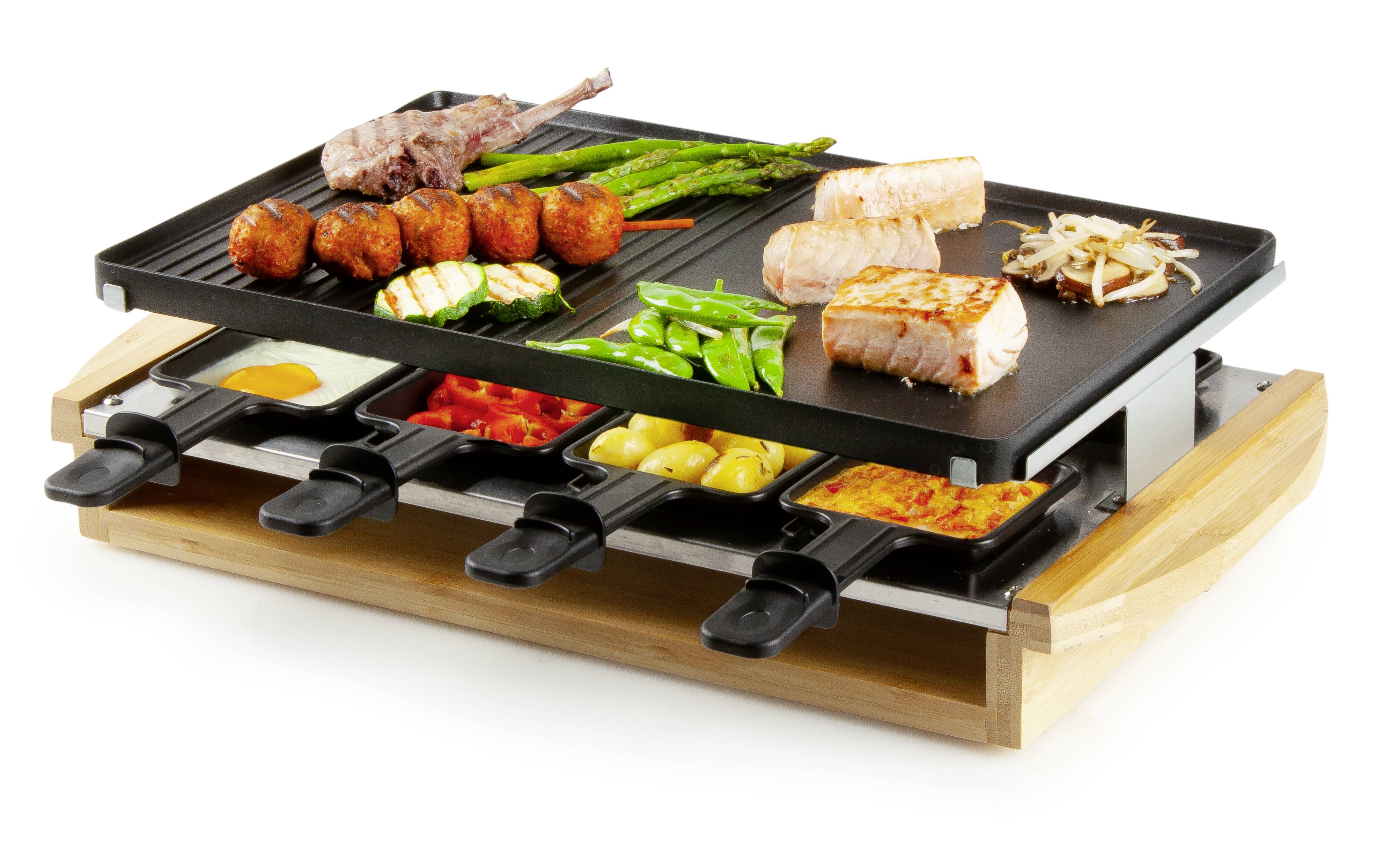 Ein Raclette-Grill mit Gemüse, Fleisch und Käse auf der oberen Grillplatte und mehreren kleinen Pfännchen darunter, die Käse schmelzen.