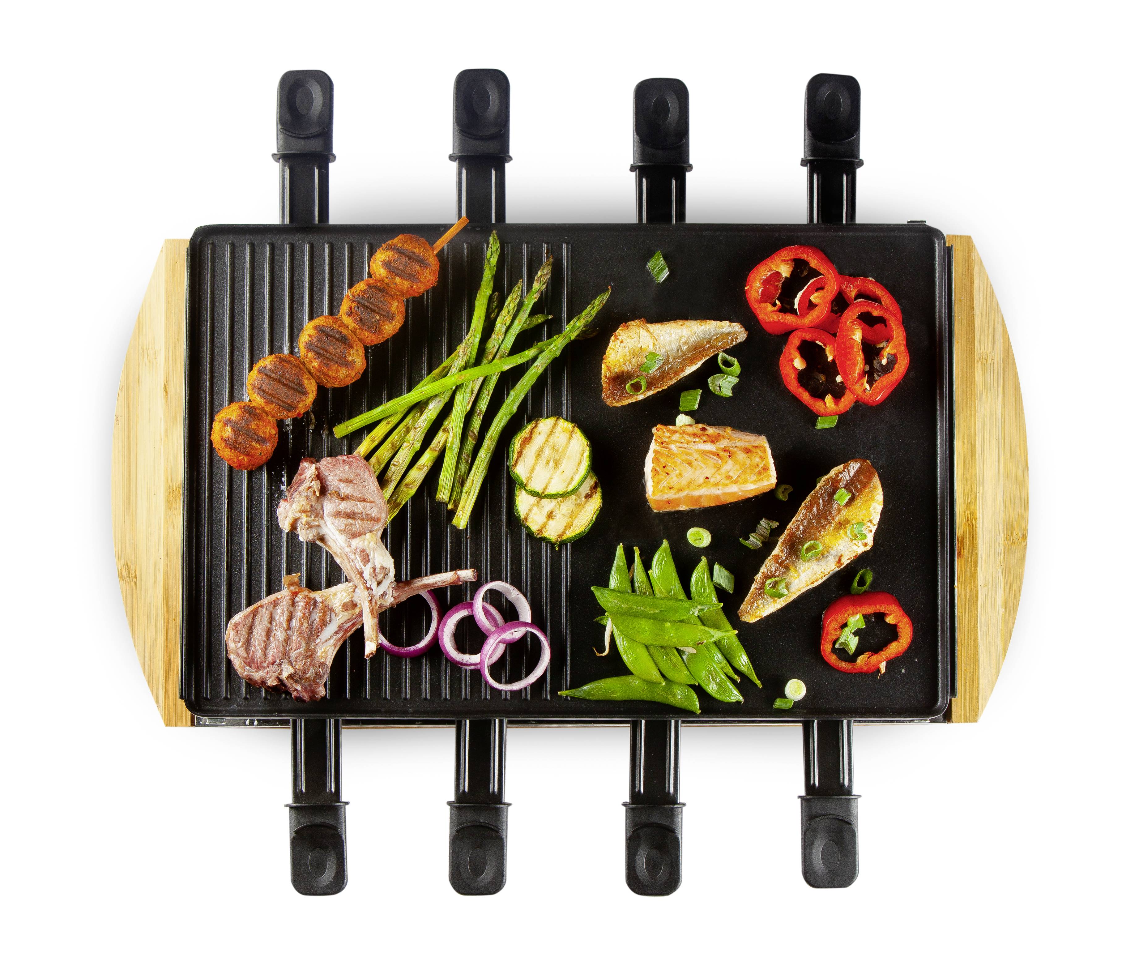 Gegrilltes Essen auf einem Raclette-Grill: Lachs, Zucchini, Spargel, Paprika, Tomaten, Lammkoteletts, Zwiebeln und Zuckerschoten.