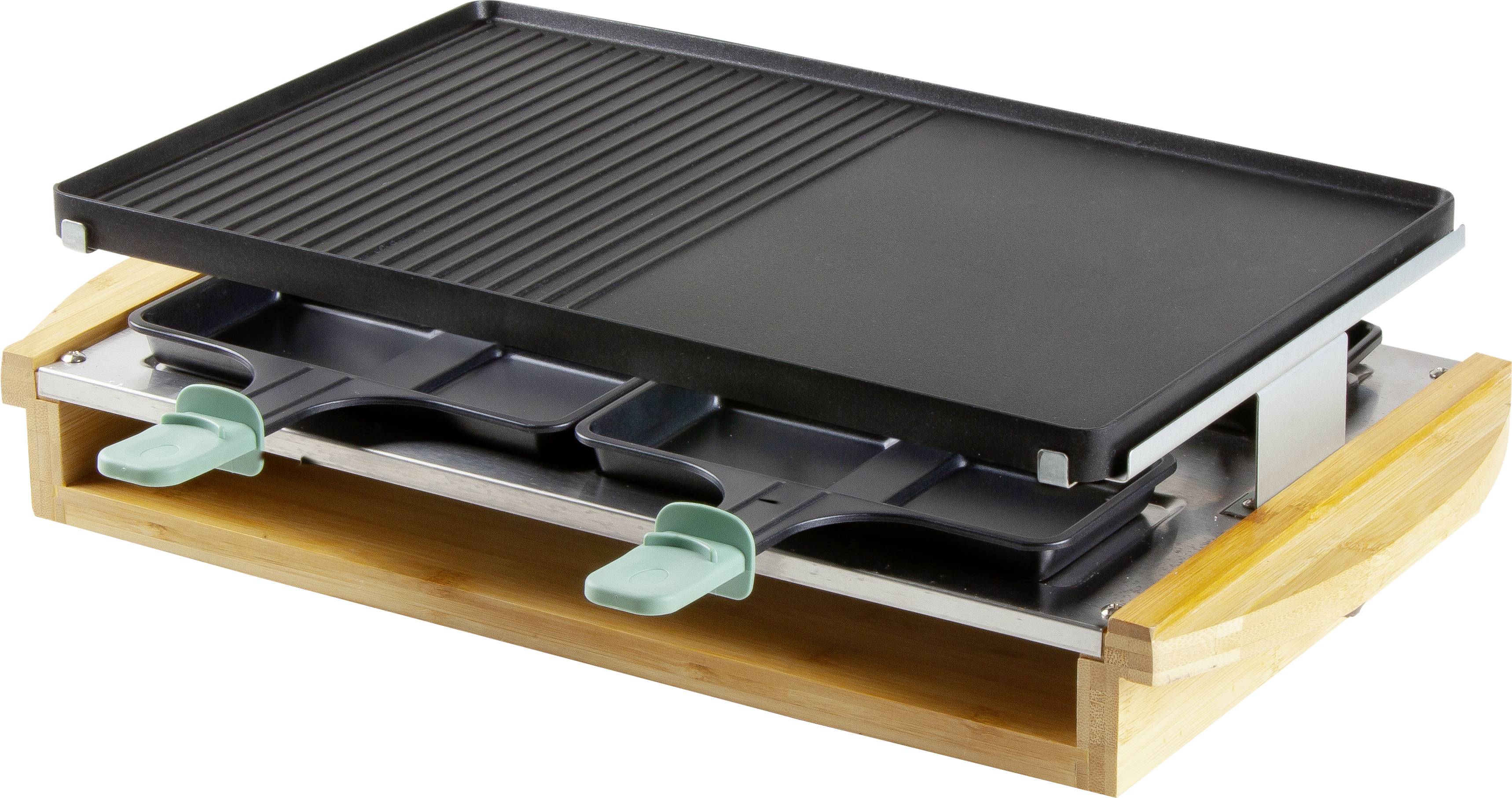 Ein elektrischer Tischgrill mit glatter und geriffelter Grillfläche, darunter zwei Raclette-Pfännchen mit grünen Griffen.