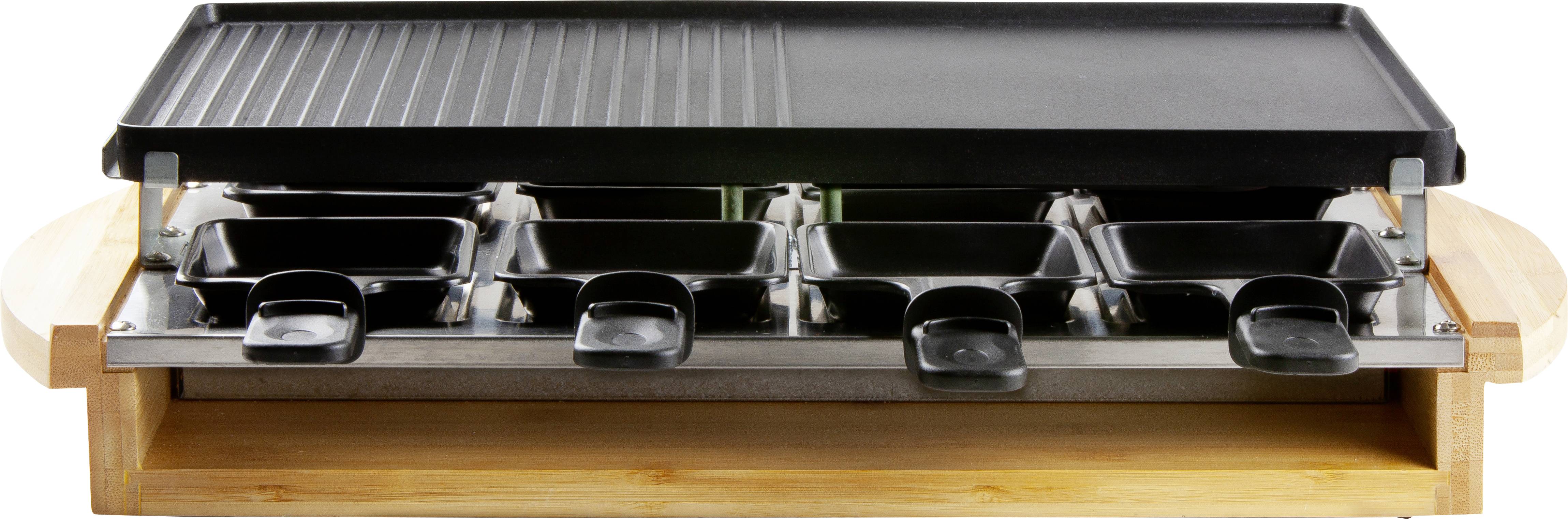Ein Raclette-Grill mit acht kleinen Pfännchen darunter und einer glatten, schwarzen Grillplatte oben, präsentiert auf einem Holzbrett.