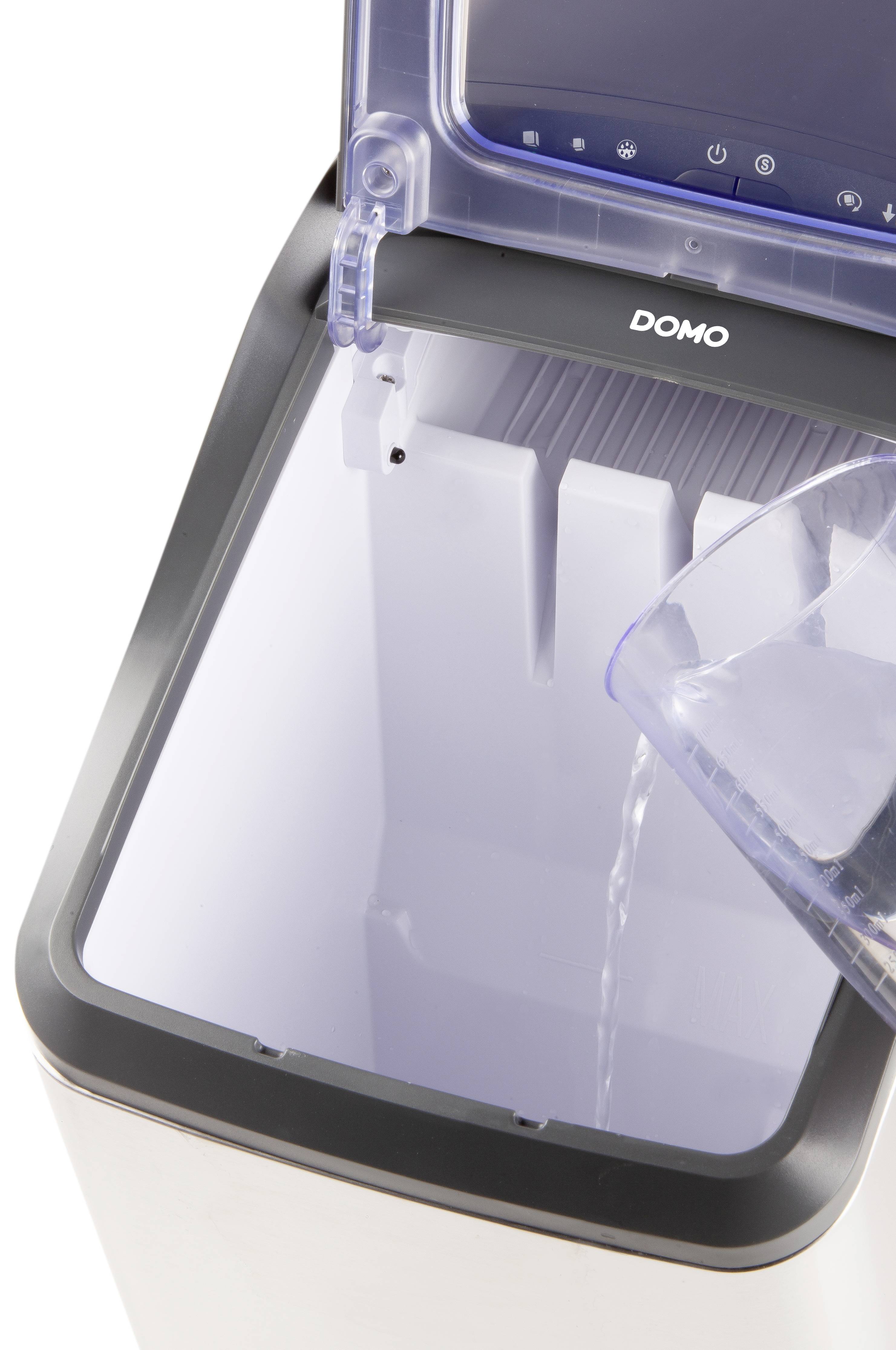 Ein Eiswürfelbereiter wird von oben befüllt. Wasser wird in den transparenten Behälter gegossen.
