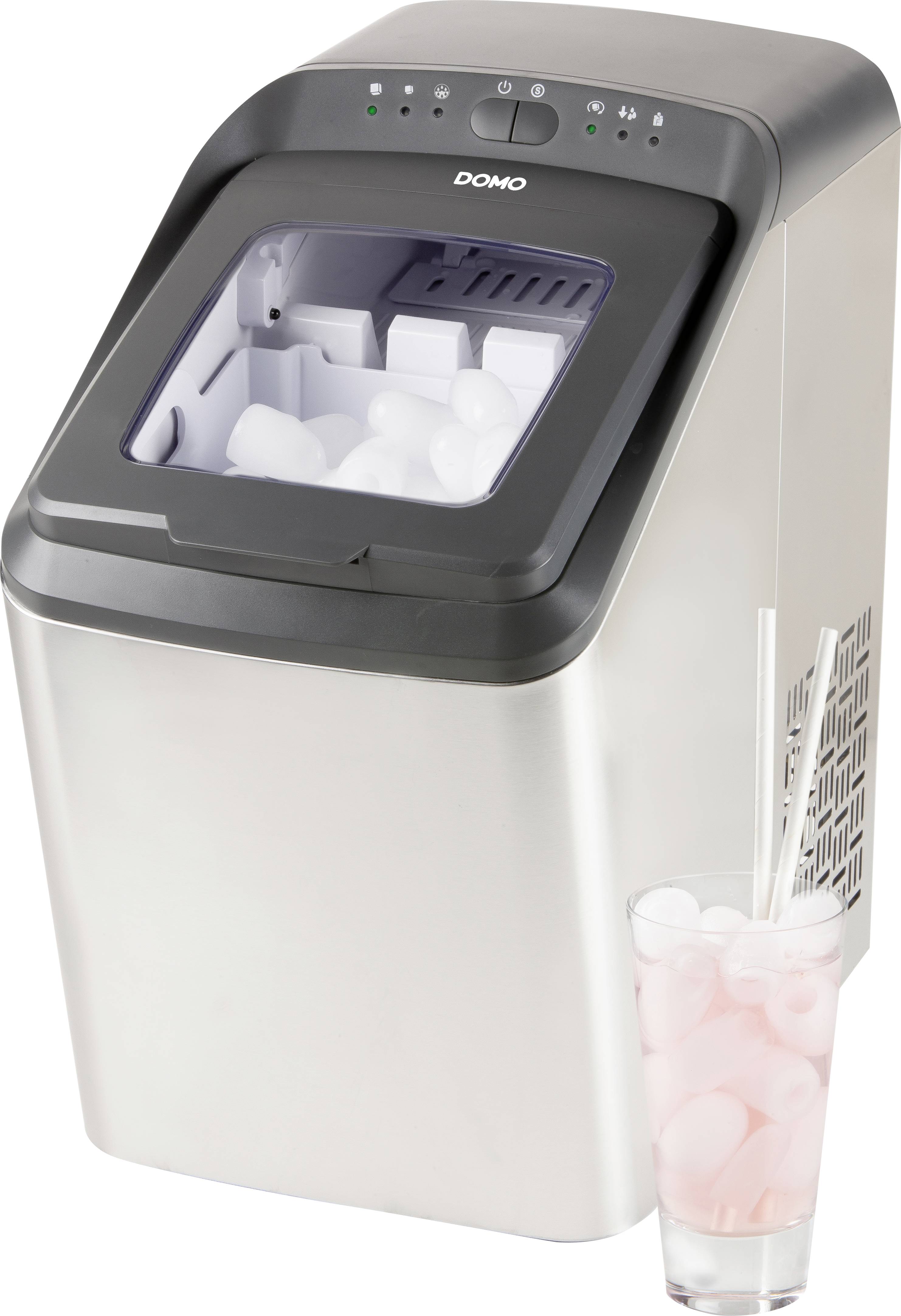 Ein silberner Eiswürfelbereiter mit offenem Deckel, gefüllt mit Eiswürfeln. Daneben ein Glas mit rosa Getränk und Eiswürfeln.