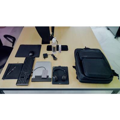 Ein aufgeräumter Schreibtisch mit Laptop, Tastatur, Mauspad, Kopfhörern, Stift, Rucksack, Wasserflasche und Desinfektionsmittel.