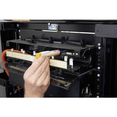 Eine Hand installiert eine Patrone in einen 3D-Drucker. Im Hintergrund sind Teile des Druckers sichtbar.